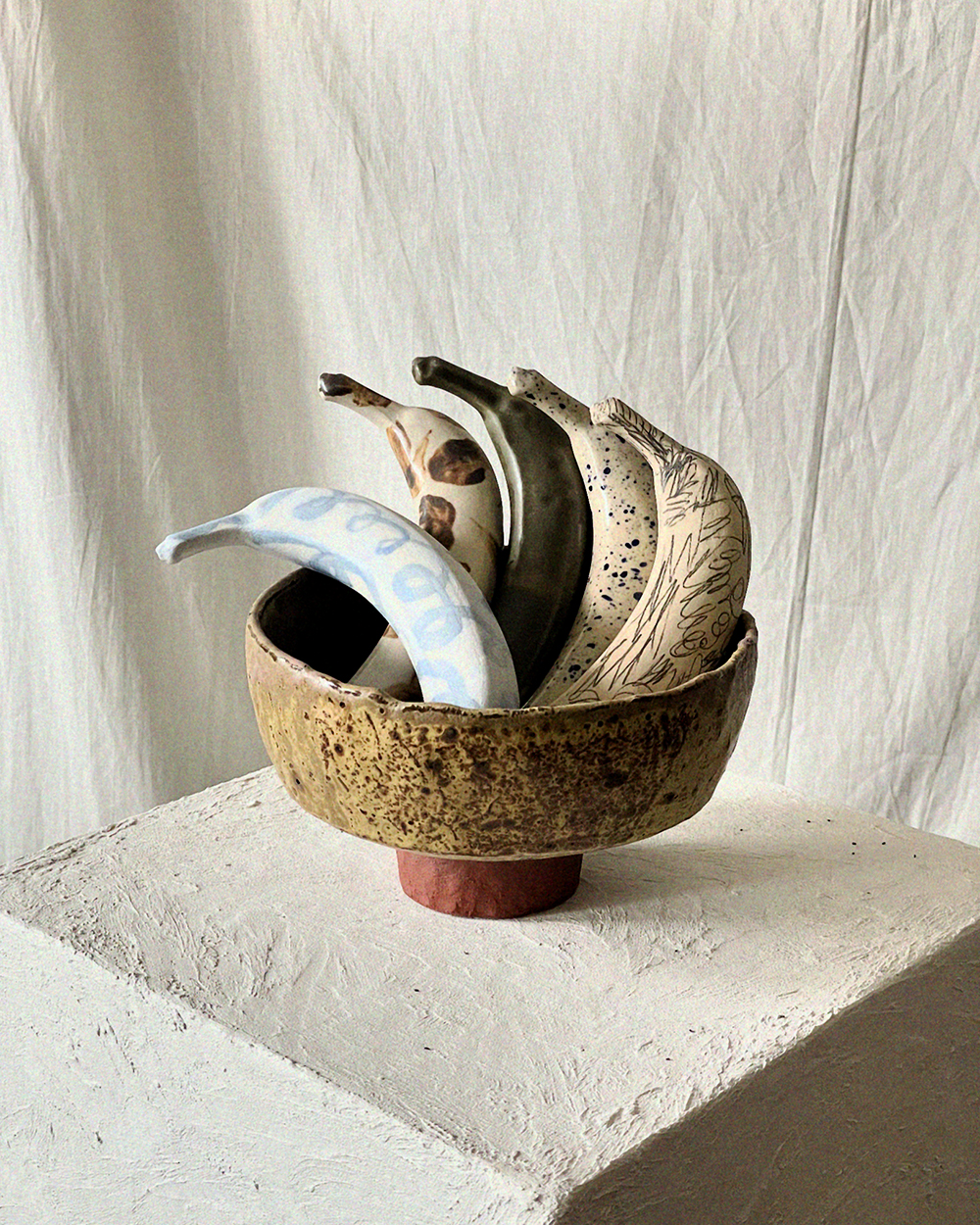 Ceramic bananas in a stoneware bowl